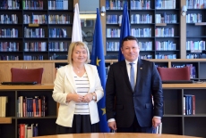 dyrekyor i ambasador na tle flag Polski, Rumunii i Unii Europejskiej