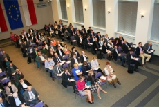 Widok na salę z góry, na której siedzą uczestnicy konferencji.