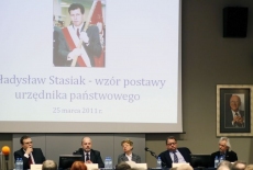 Paneliści siedzą przy stole prezydialnym,