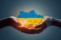 dwie dłonie trzymają mapę Ukrainy w barwach flagi