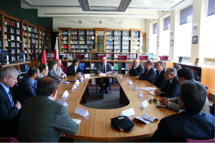 Goście spotkania siedzą w bibliotece KSAP przy owalnym stole